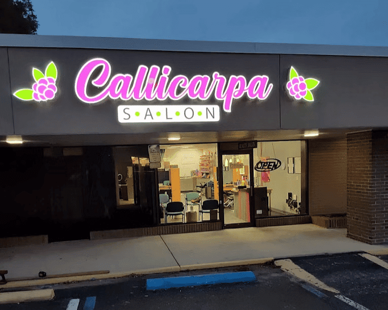 Callicarpa Salon exterior, neon sign lit, accessible parking in front.