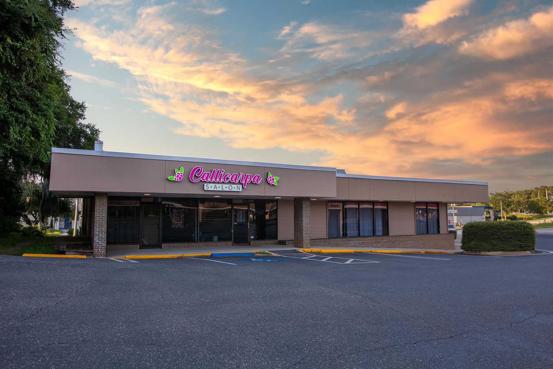 Exterior of Callicarpa Salon under a vibrant sunset sky.