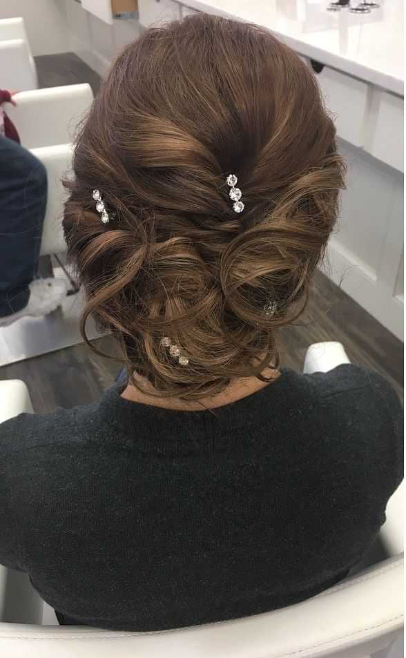 Woman with an elegant, twisted updo hairstyle adorned with small, sparkling hairpins.